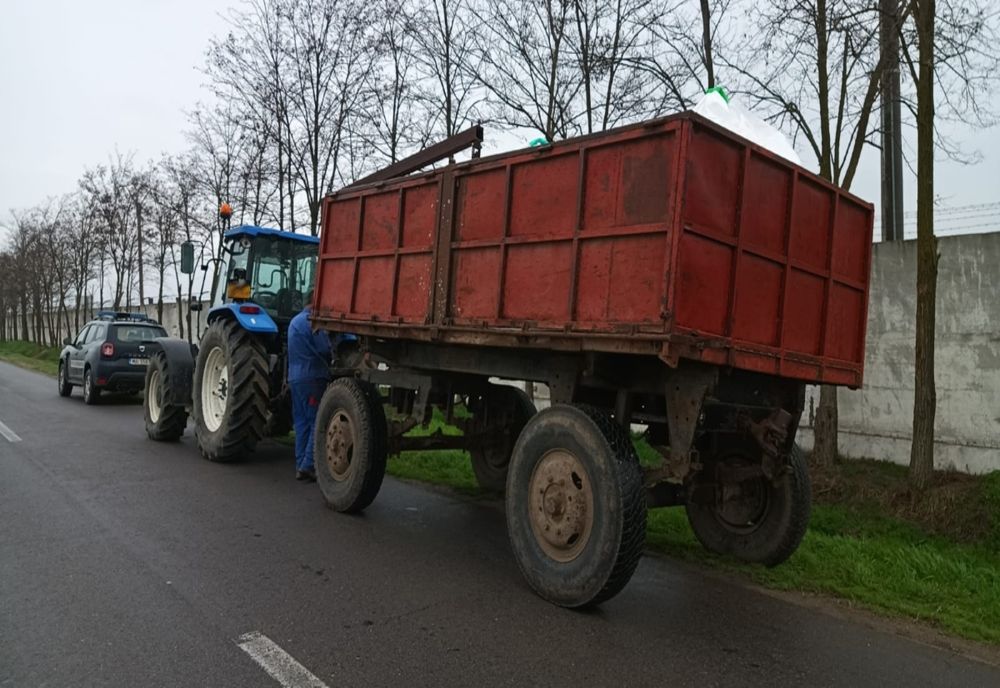 Conducea un tractor pe DJ212 fără permis de conducere și cu remorcă neînmatriculată 